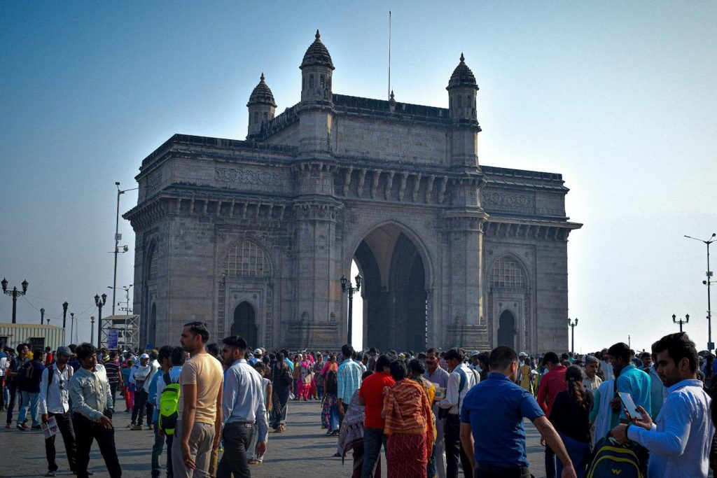 Vibrant crowd gathered at the famous Gateway of India in Mumbai, India during the day.